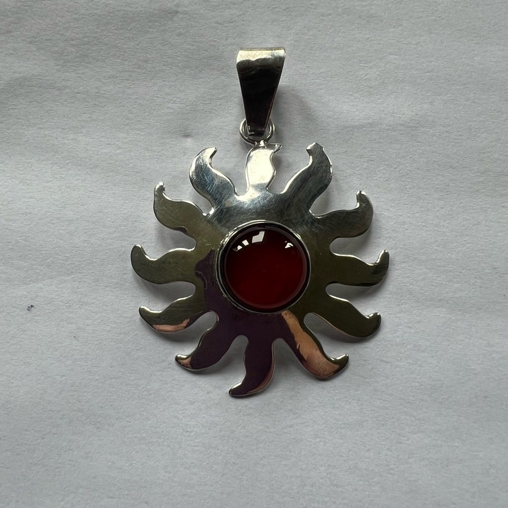 Radiant Silver Sunburst Pendant with Rust Stone Accent